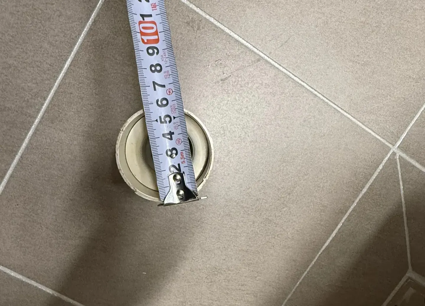 강남구 개포동 화장실 욕조 배수구 트랩 지름을 줄자로 측정하는 사진
