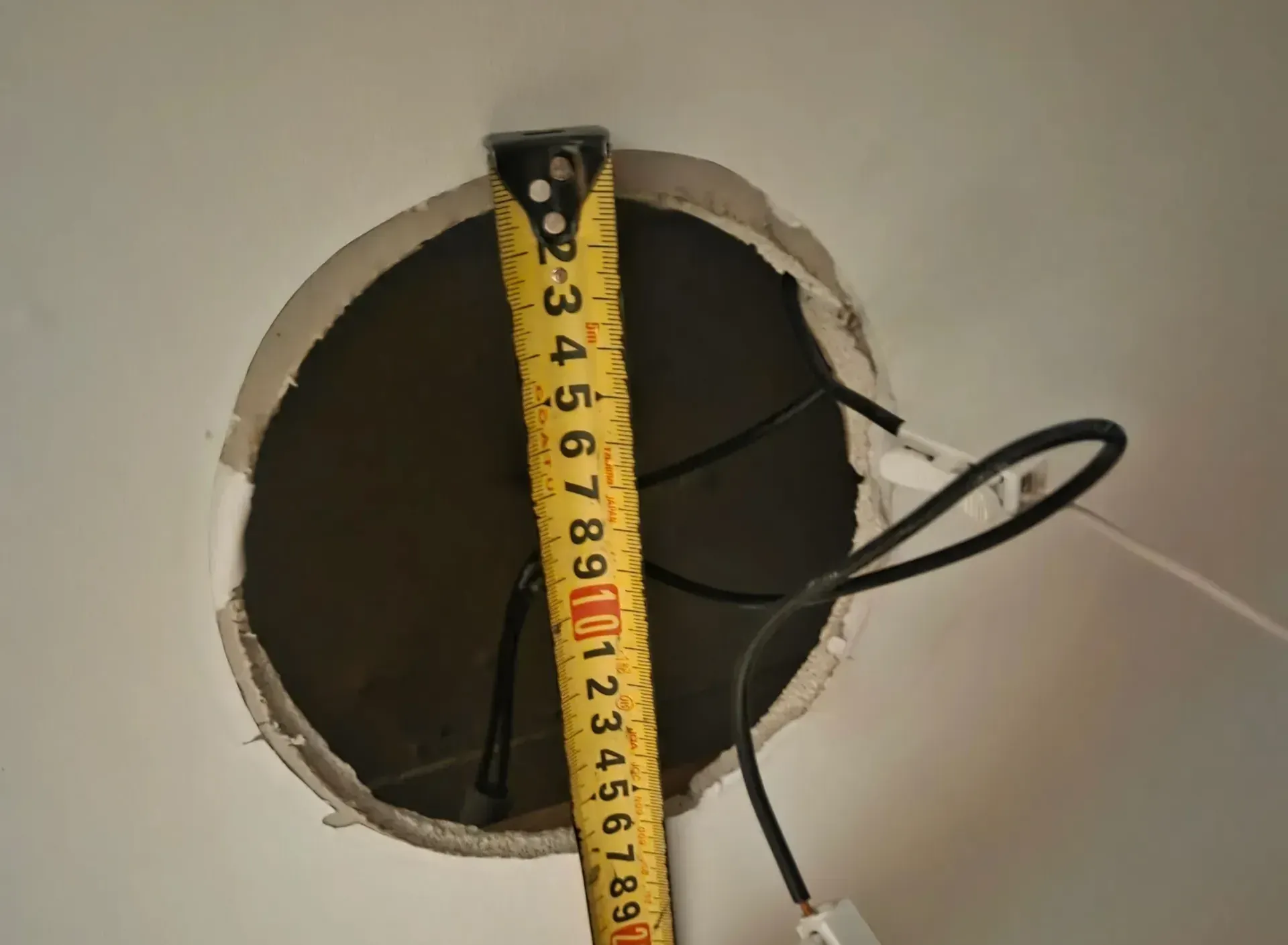 상일동 팬트리 천장 매입 구멍을 줄자로 실측하는 모습